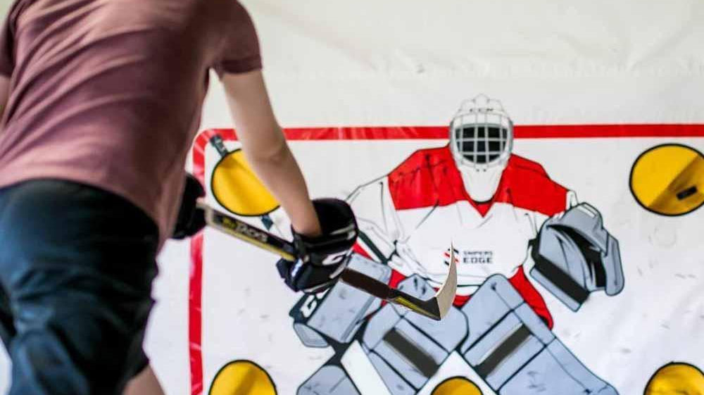 A boy practicing using his hockey shooting tarp