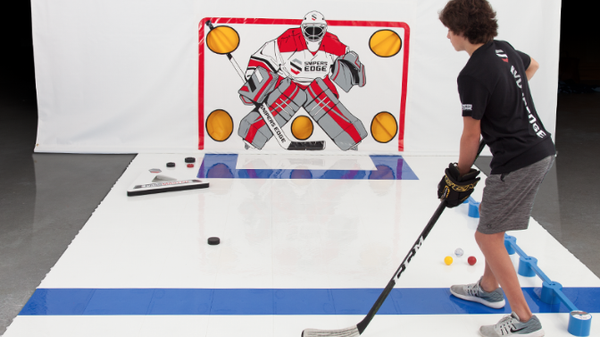 A kid practicing hockey skills indoors using our Slick Tiles