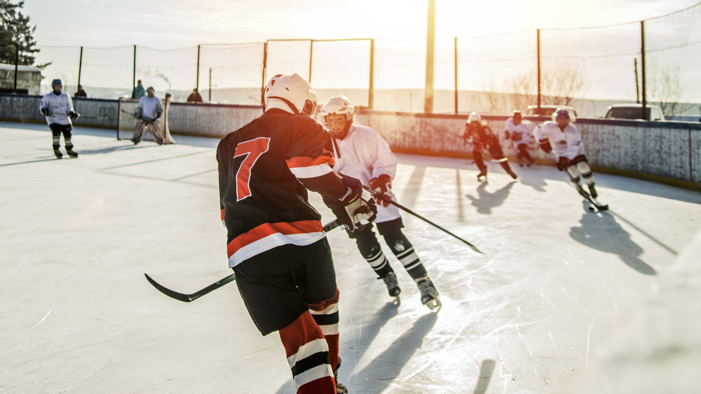 Two teams playing hockey outdoors
