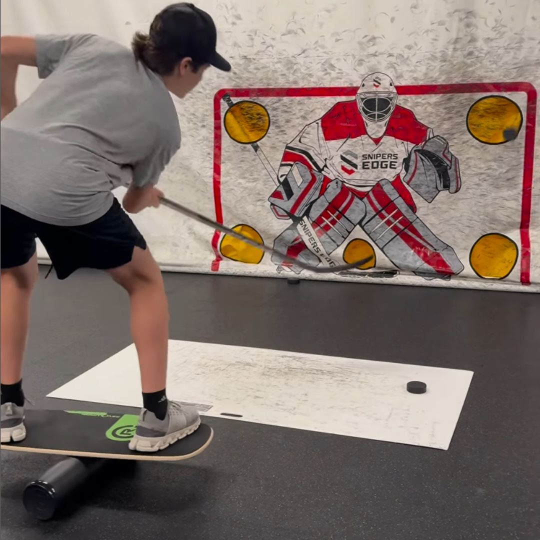 Youth player training with hockey shooting pad and hockey shooting tarp