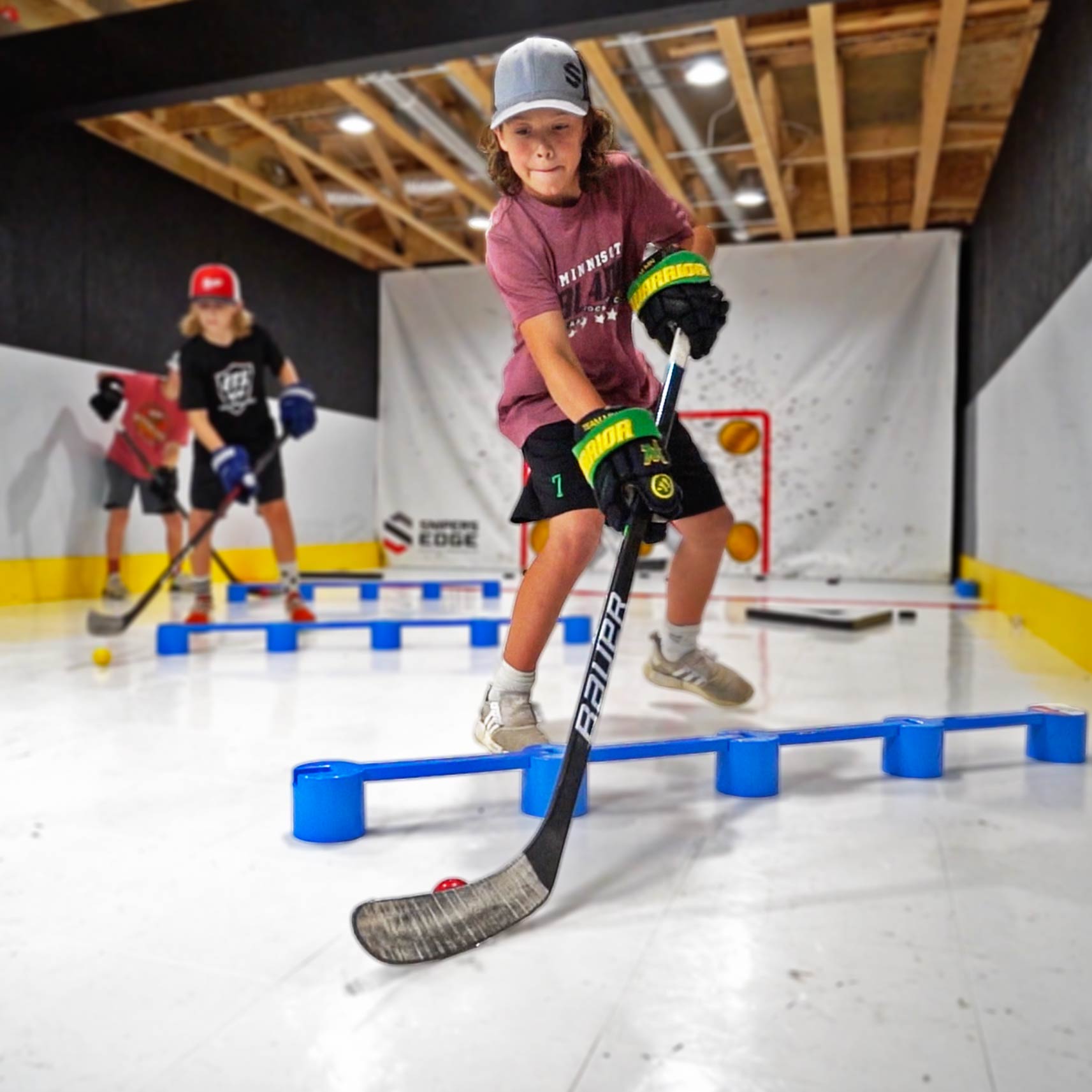 youth player using a hockey stickhandling ball and dryland hockey tiles