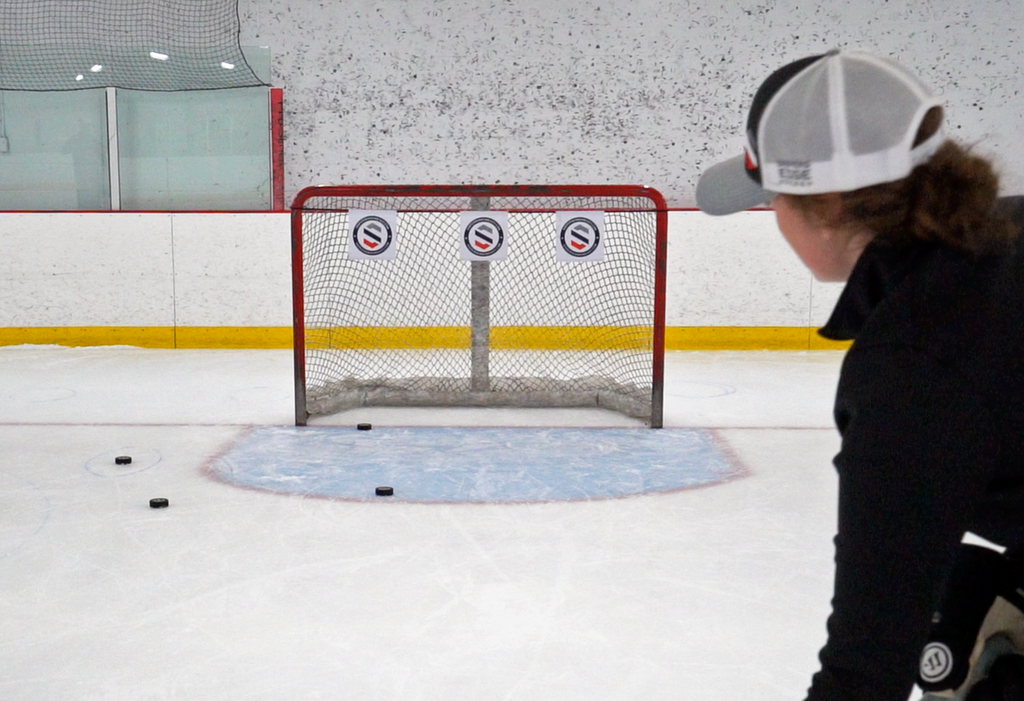 Girl practicing shooting goals and hitting her Hockey Shooting Targets 