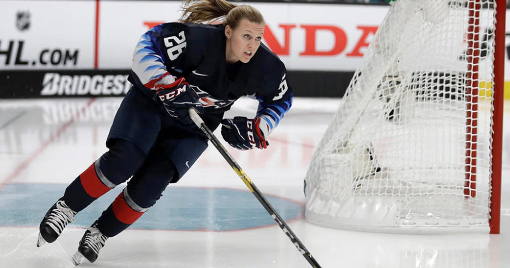 Photo of player from USA Olympic women's hockey team skating behind a goal