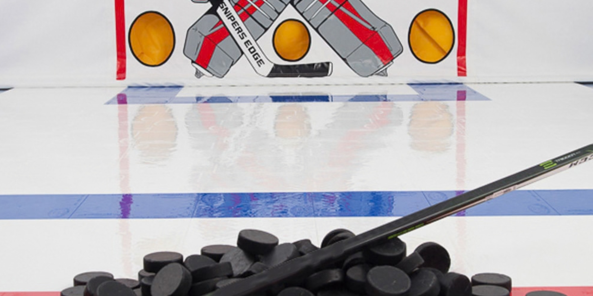 Pile of pucks with hockey shooting tarp and dryland hockey tiles