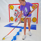 Girl in purple Sniper Sam shirt using yellow speed ball with Sweethands practicing hockey 