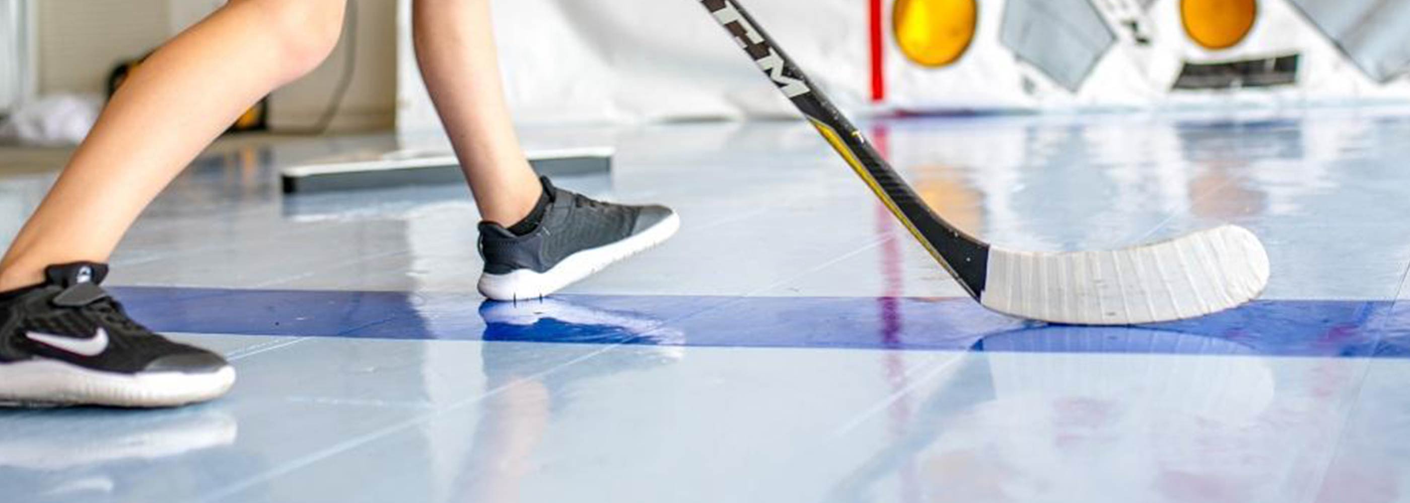 Close up photo of kid using dryland hockey tiles