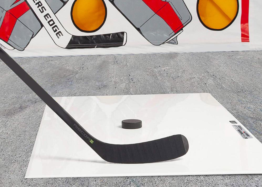 a puck and stick ready to shoot on a shooting pad
